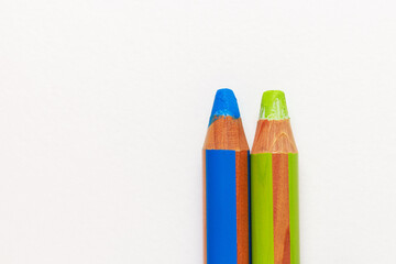 Two large thick colored pencils in green and blue for children