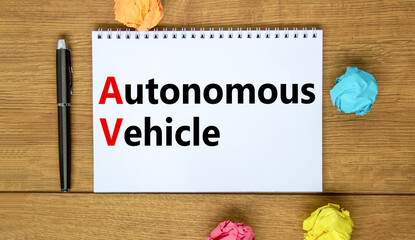 Naklejka premium AV autonomous vehicle symbol. Concept words AV autonomous vehicle on white note on a beautiful wooden background. Metallic pen. Business technology AV autonomous vehicle concept. Copy space.