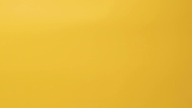 Man hand holds square cardboard box on yellow background. Concept of delivery service. Packaging template mockup.