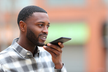 Man with black skin using voice recognition on cellphone