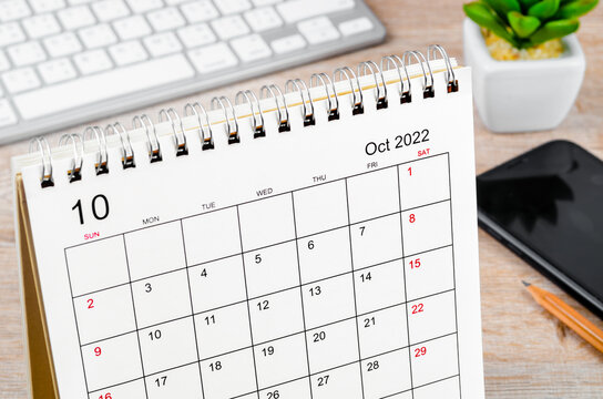 October 2022 desk calendar on wooden table.