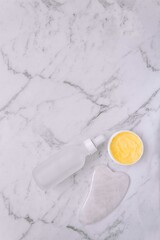 Guasha and cream textures on the marble surface