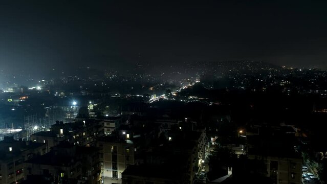Timelapse of Stunning Vehicle Lights Moving Amidst Guwahati City Houses, India, at Night.
