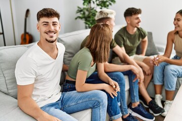 Group of young friends smiling happy sitting on the sofa at home.