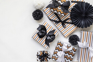 Gift boxes wrapped in Striped and chevron geometric paper with black ribbon bows close up