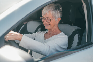 Happy owner. Handsome mature woman sitting relaxed in his newly bought car looking at the road...
