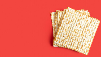 Matzah for Jewish holiday Pesach on red background.