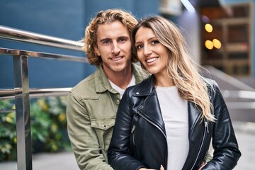 Man and woman couple smiling confident hugging each other at street