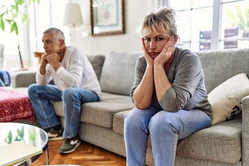 Senior caucasian couple in trouble sitting on the sofa at home.