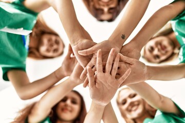 Group of young volunteers woman smiling happy with hands together at charity center.