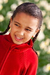 African American mixed race girl standing smiling in a field of daffodils