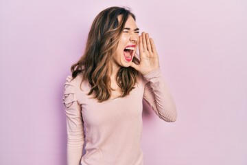 Young hispanic girl wearing casual clothes shouting and screaming loud to side with hand on mouth. communication concept.