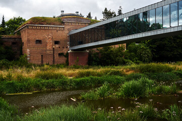 A fragment of a historic Prussian fortress and a modern footbridge over the Warta River