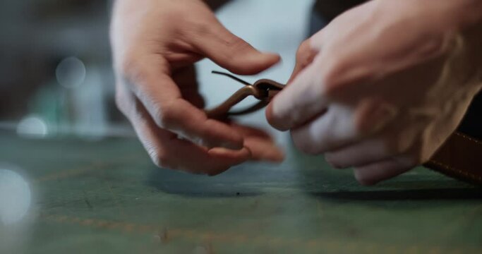 Artisan attaching buckle to leather belt