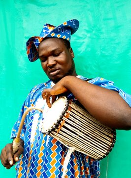 African Man In Blue Floral Shirt Playing Drum