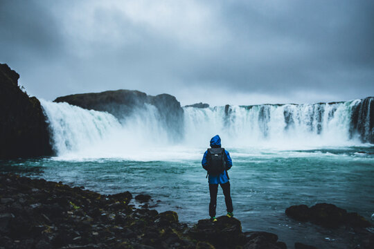 Back view of man with backpack standing facing go&eth;afoss waterfa