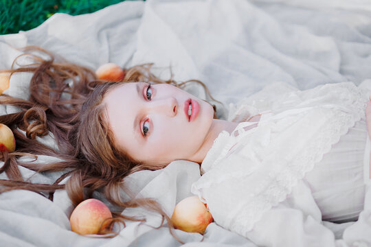 Blonde woman lying on floor surrounded by peaches