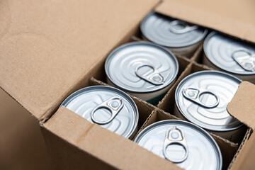 Food cans in an open cardboard box. Concept image for supply chain disruption, food shortage,...