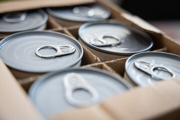 Food cans in an open cardboard box. Concept image for supply chain disruption, food shortage,...