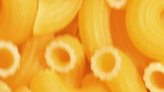 Uncooked Chifferi Rigati Pasta - Top View, Close-Up. Fat and Unhealthy Food. Classic Dry Macaroni, Moving Downward Background. Italian Culture and Cuisine. Raw Golden Pasta Texture in Move