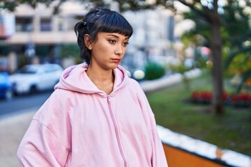 Young woman standing with relaxed expression at park