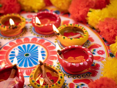 Diwali Rangoli with lit diyas and marigold flowers