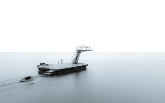 Grayscale photo of concrete platform in a body of water