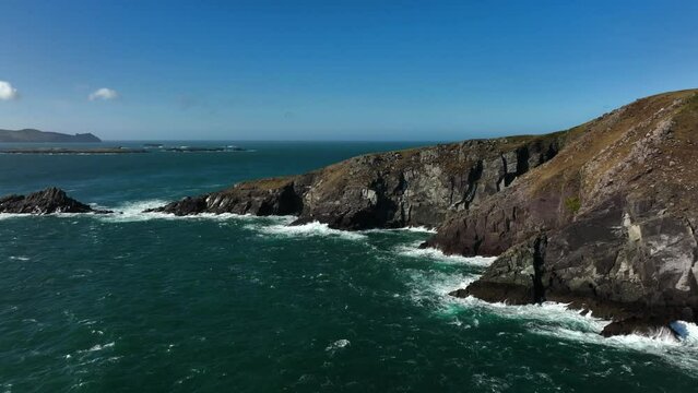 Coumeenoole Bay, Kerry, Ireland, March 2022. Drone tracks east along the cliffs at Dunmore head off Ventry with the Blasket Islands and the North Atlantic Ocean in the background.