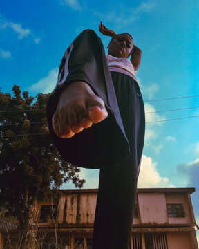 Low angle view of young woman raising one leg