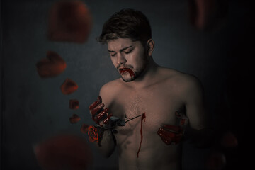 Man bleeding from his chest torn by rose surrounded by red roses