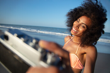 Young Afro woman in swimwear smiling taking selfie