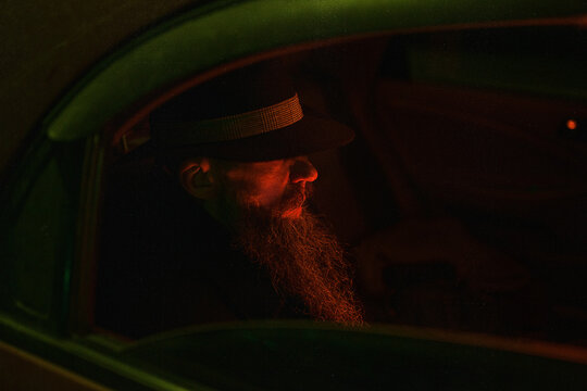 Man in black hat sitting inside car