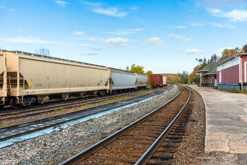 Railroad cars stationary in a small train station on a clear autumn day. Huntsville, ON, Canada.