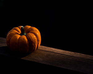 Orange pumpkin on brown wooden table