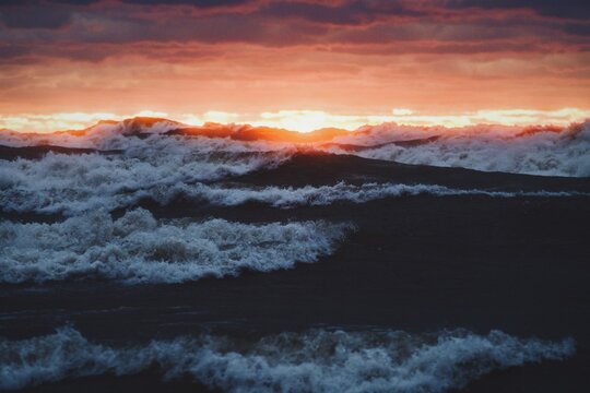 Ocean waves crashing on shore during sunset