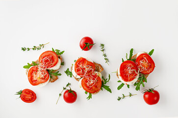 Italian food concept. Open sandwiches with mozzarella, tomatoes and arugula on white background.Copy space