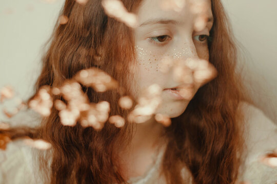 Portrait of young woman with glitter freckle and red hair