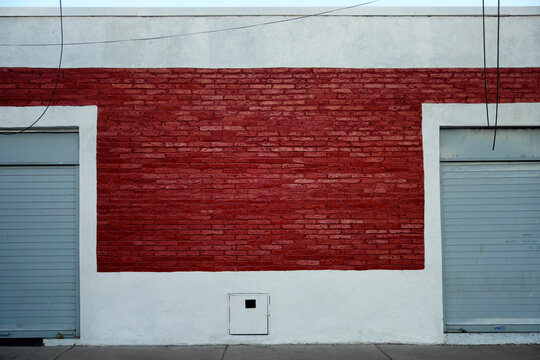 Fototapeta Red brick building with roller shutters