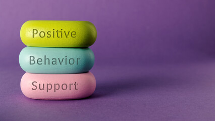Positive behavior support words written on colorful wooden blocks. Purple background with copy space. - obrazy, fototapety, plakaty
