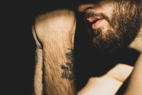 Side view of bearded man with tattoo on his wrist