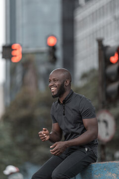 Smiling Man In Gray Shirt Sitting Outdoor