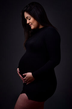 Studio portrait of pregnant woman in dark dress
