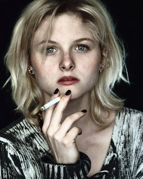 Woman in black and white shirt smoking cigarette