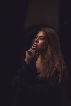 Woman in dark shirt against dark background