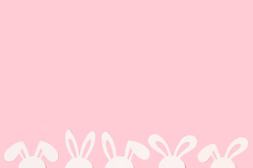 Diseño creativo hecho con orejas de conejo blancas sobre un fondo rosa pastel. Vista superior y de...