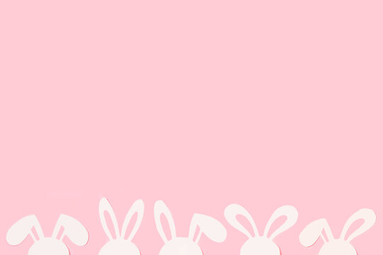 Dise&ntilde;o creativo hecho con orejas de conejo blancas sobre un fondo rosa pastel. Vista superior y de cerca. Copy space. Concepto: Pascuas
