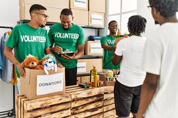 Group of young african american volunteers helping people at charity center.
