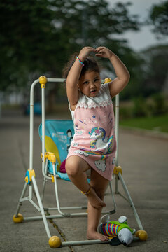 Young Girl Dancing Ballet Beside A Kid Swing Chair Outdoor