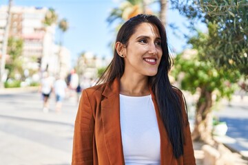 Young hispanic woman smiling confident walking at street