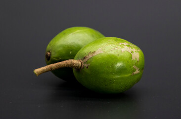 two hog plum fruits close-up isolate on black background.